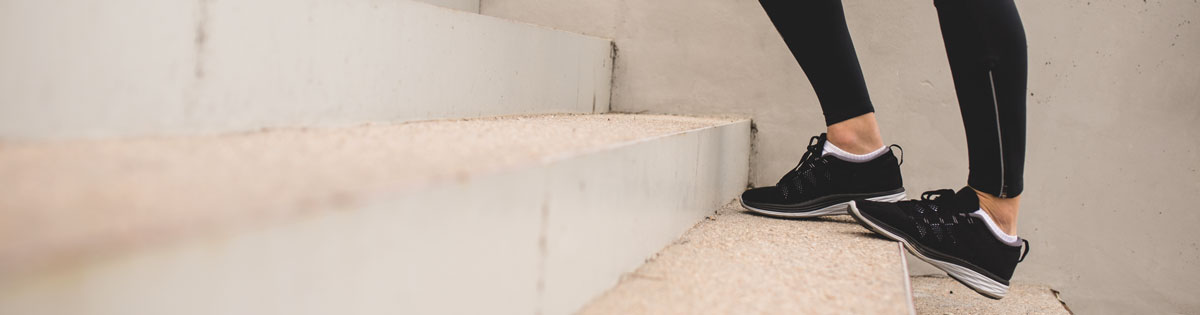 woman stretching calves on stair steps